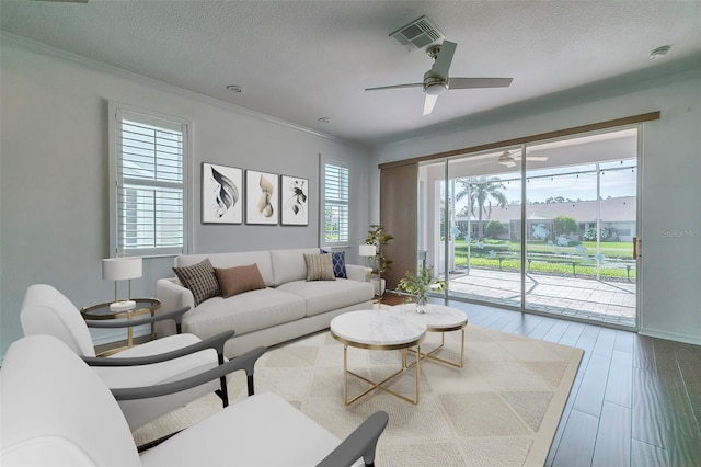 living room with wood-type flooring, a textured ceiling, crown molding, and ceiling fan