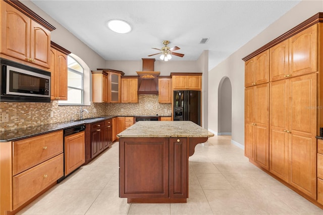 kitchen with stainless steel microwave, a kitchen island, ceiling fan, black refrigerator with ice dispenser, and premium range hood