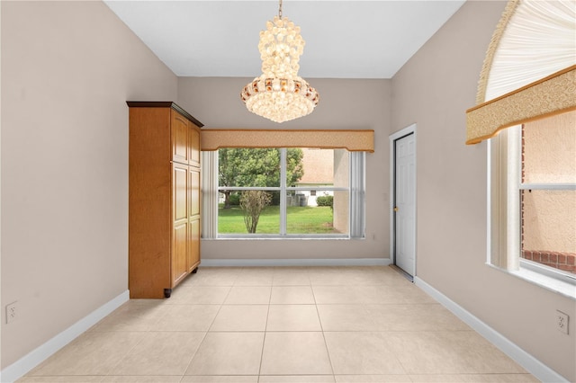 unfurnished room with a notable chandelier and light tile patterned floors