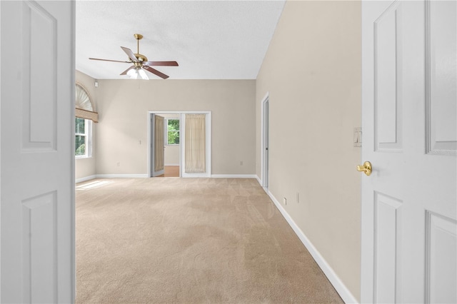 carpeted empty room featuring ceiling fan and a textured ceiling