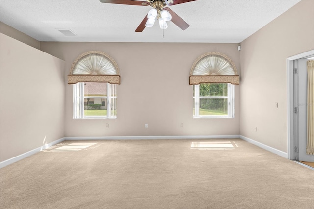 unfurnished room with carpet floors, ceiling fan, and a wealth of natural light