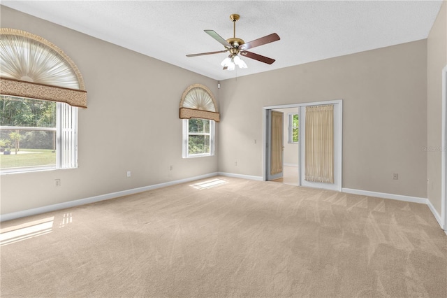 carpeted spare room with a textured ceiling and ceiling fan