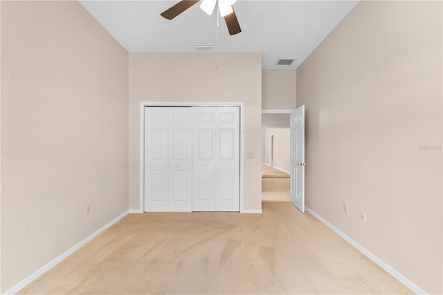 unfurnished bedroom with light carpet, ceiling fan, and a closet