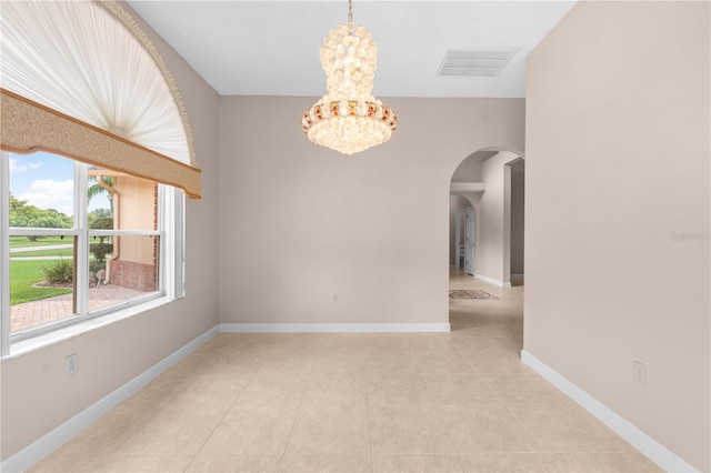 spare room featuring light tile patterned floors and a notable chandelier