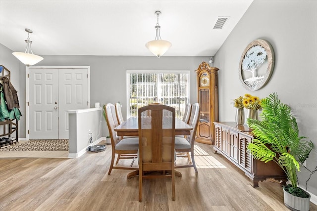 dining space featuring light wood-style floors, baseboards, and visible vents