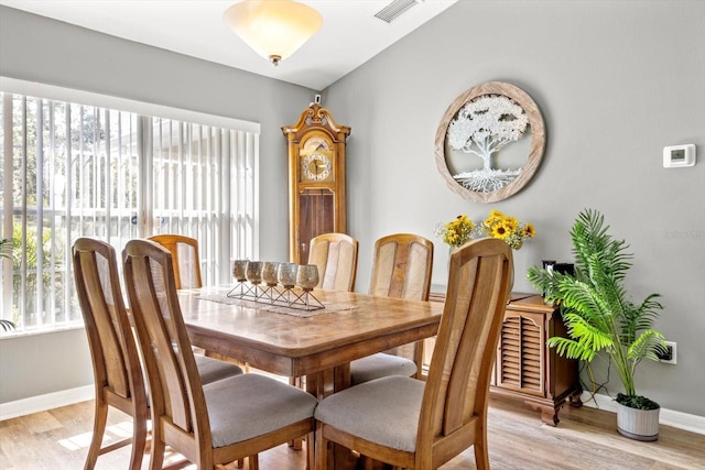 dining space with light wood finished floors, visible vents, and baseboards