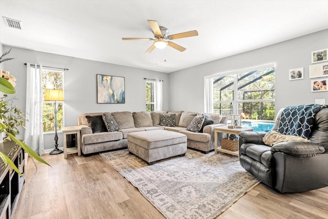 living area featuring a ceiling fan, visible vents, and light wood-style floors