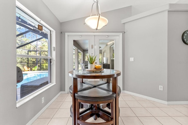 dining room with lofted ceiling, light tile patterned floors, and baseboards