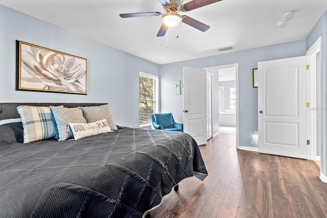 bedroom featuring ceiling fan, wood finished floors, visible vents, and baseboards