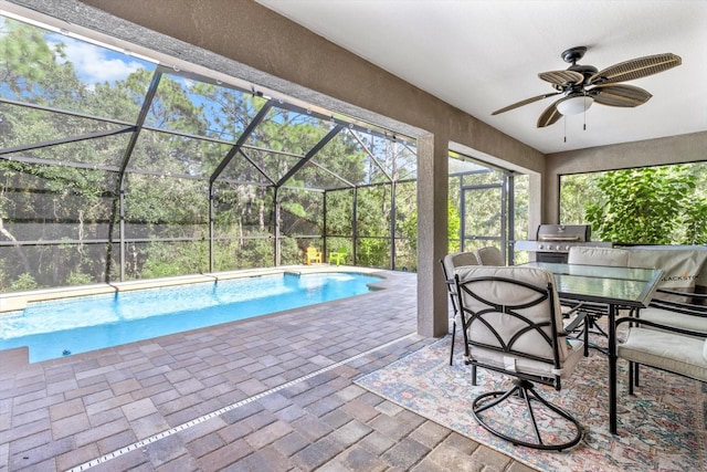 outdoor pool featuring a patio area, ceiling fan, glass enclosure, and outdoor dining space