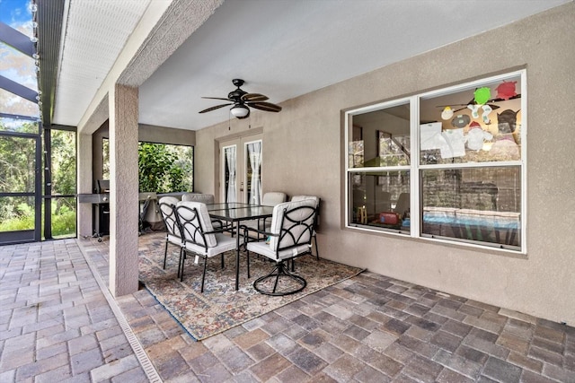 view of patio featuring a ceiling fan, outdoor dining space, french doors, and a lanai