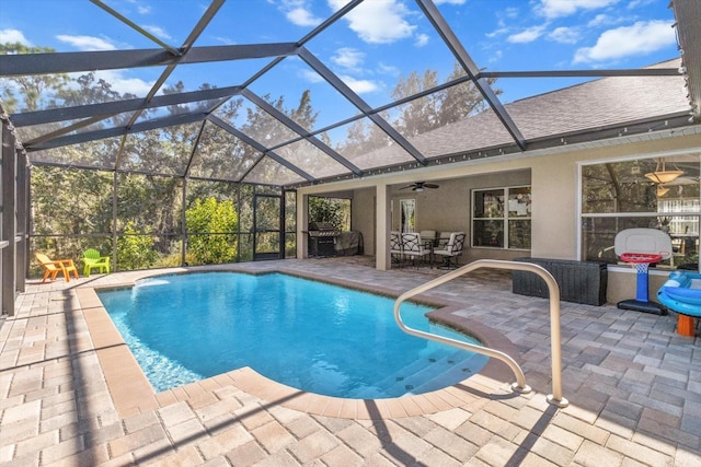 outdoor pool with a lanai, a patio area, and a ceiling fan