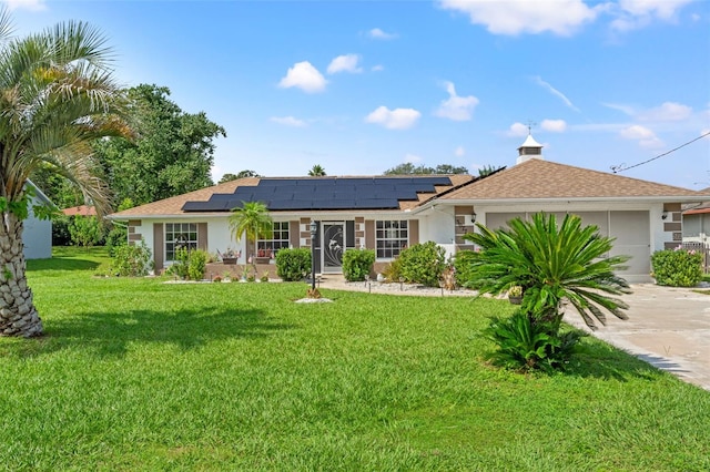 ranch-style house with a front yard, a garage, and solar panels