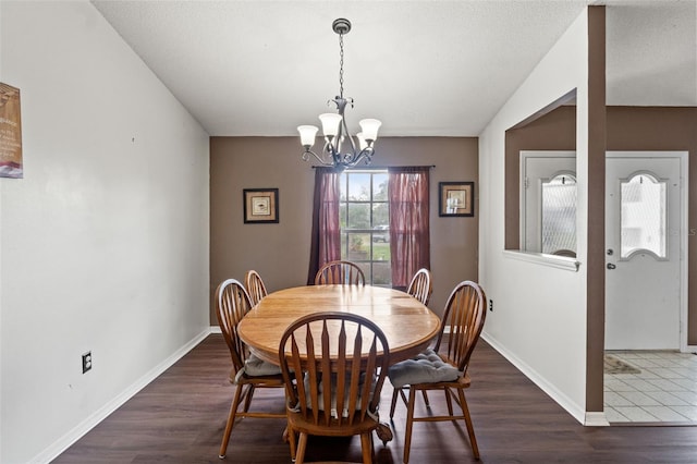 dining space featuring a notable chandelier, dark hardwood / wood-style flooring, and a textured ceiling