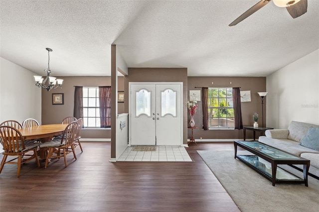 interior space featuring ceiling fan with notable chandelier, dark hardwood / wood-style floors, and a wealth of natural light