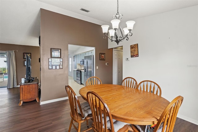 dining room with a notable chandelier and dark hardwood / wood-style flooring