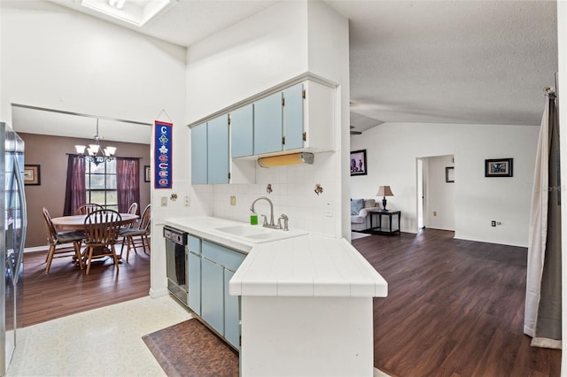 kitchen featuring blue cabinets, sink, dark wood-type flooring, stainless steel appliances, and tile counters