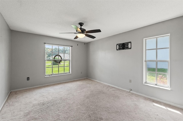 unfurnished room with ceiling fan, light colored carpet, and a textured ceiling