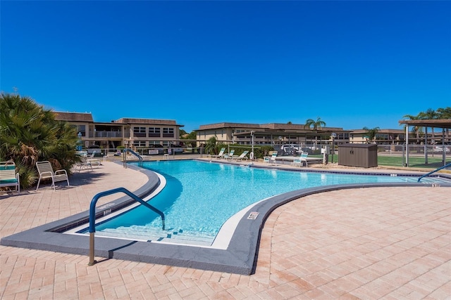 view of pool with a patio and a storage unit