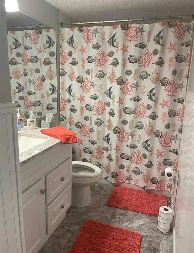 bathroom with walk in shower, vanity, toilet, and a textured ceiling