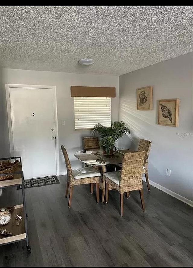 dining area featuring a textured ceiling and dark hardwood / wood-style flooring