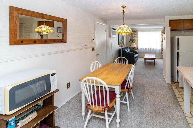 dining area featuring a textured ceiling and a wall mounted air conditioner