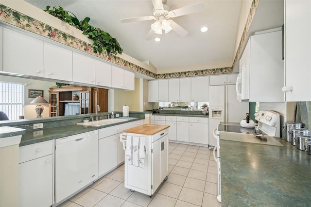 kitchen featuring white cabinetry, a center island, white appliances, and sink