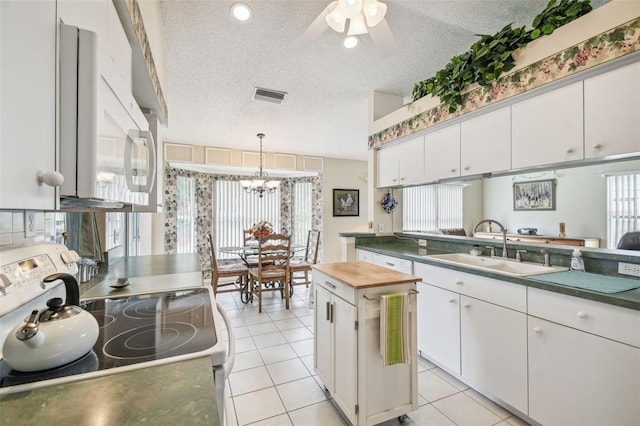 kitchen featuring white cabinets, stainless steel stove, a textured ceiling, and a kitchen island