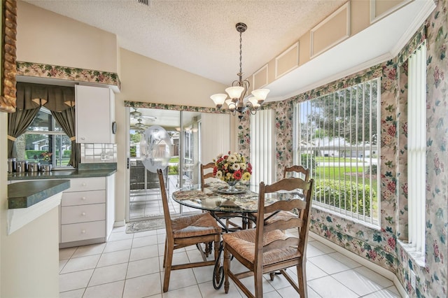 tiled dining area with lofted ceiling, a textured ceiling, and a notable chandelier