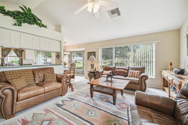 living room featuring ceiling fan, a textured ceiling, high vaulted ceiling, and light colored carpet