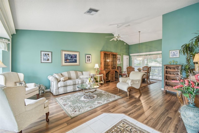 living room with hardwood / wood-style flooring, ceiling fan, and vaulted ceiling