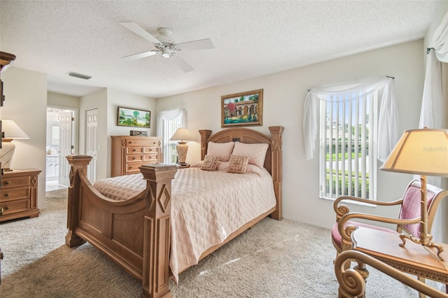 carpeted bedroom featuring ensuite bathroom, ceiling fan, and a textured ceiling