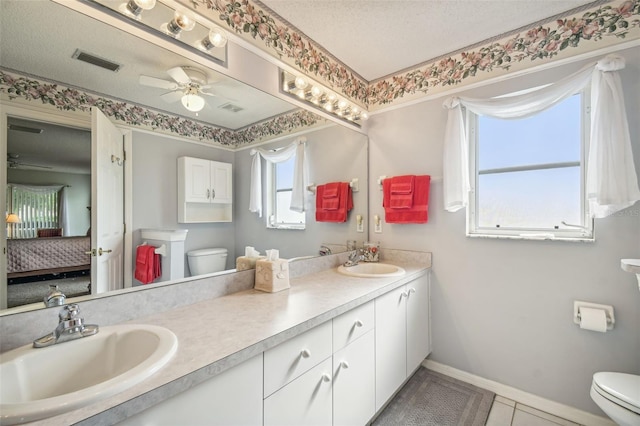 bathroom featuring plenty of natural light, toilet, and a textured ceiling