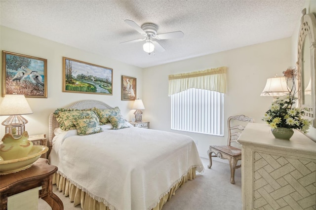 carpeted bedroom featuring a textured ceiling and ceiling fan