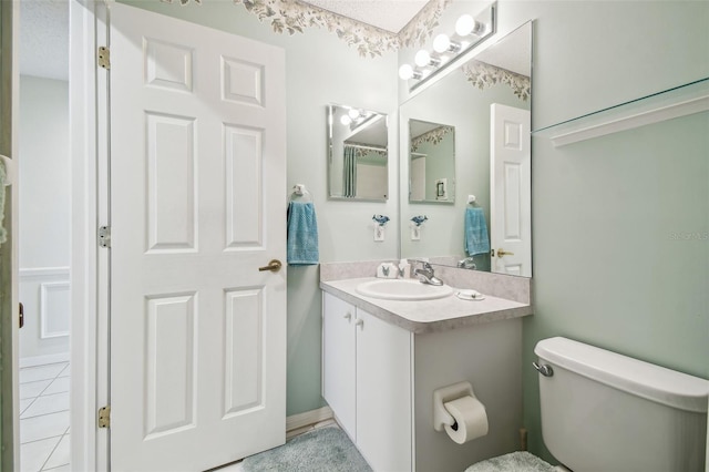 bathroom featuring vanity, tile patterned floors, and toilet