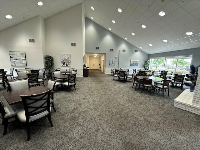 dining area with a high ceiling and dark colored carpet