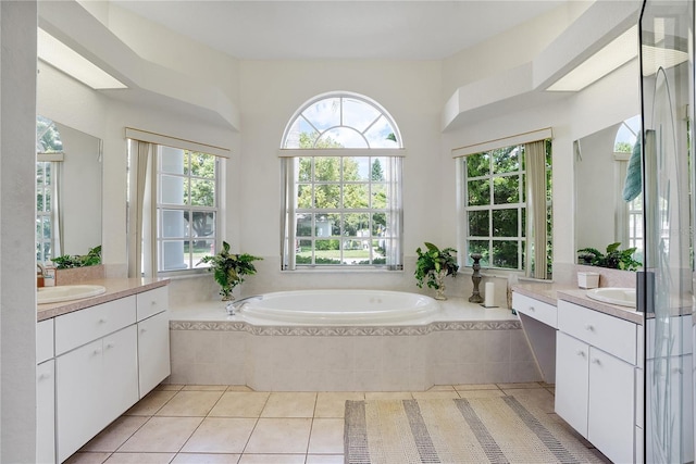 bathroom featuring tiled tub, vanity, and tile patterned floors