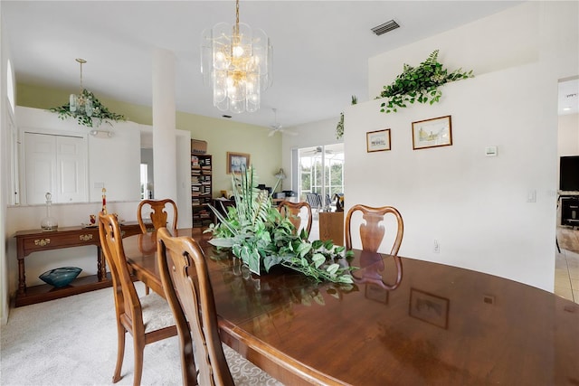 dining area featuring light carpet and ceiling fan with notable chandelier