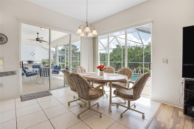 dining room with ceiling fan with notable chandelier and light wood-type flooring