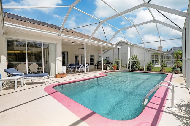 view of swimming pool featuring ceiling fan, a lanai, and a patio area