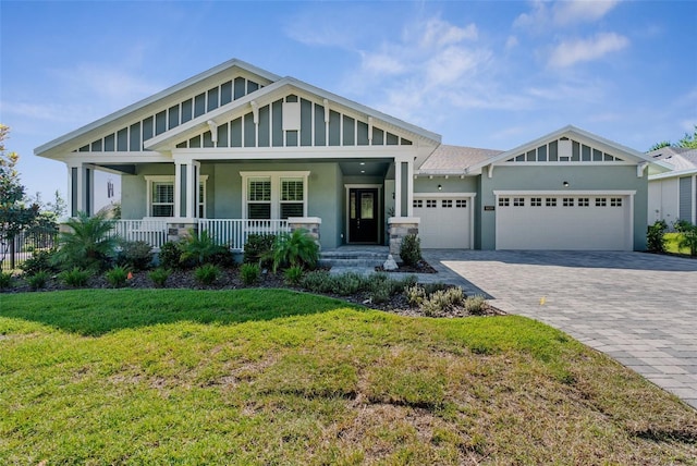 craftsman house featuring a front lawn, covered porch, and a garage