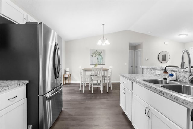 kitchen featuring lofted ceiling, sink, white cabinetry, stainless steel refrigerator, and dark hardwood / wood-style floors