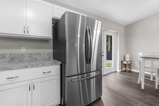 kitchen featuring stainless steel refrigerator, dark wood-type flooring, and white cabinetry