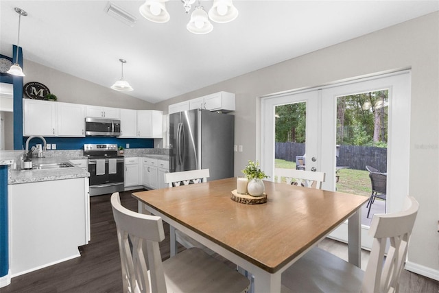 dining space featuring a notable chandelier, vaulted ceiling, sink, and dark hardwood / wood-style flooring