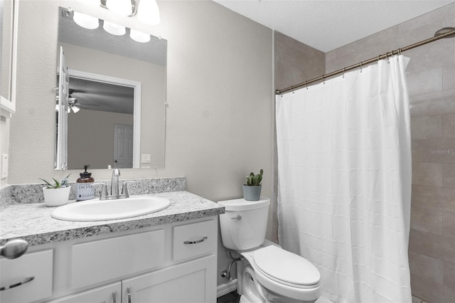 bathroom with ceiling fan, vanity, curtained shower, a textured ceiling, and toilet