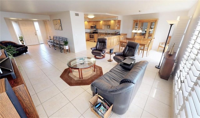 living room featuring light tile patterned flooring, sink, and a notable chandelier