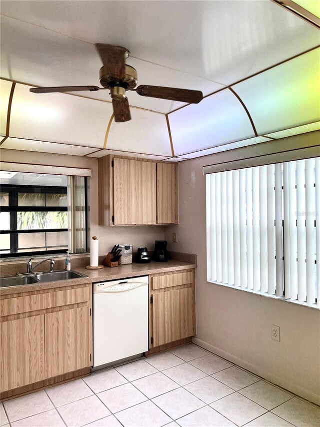 kitchen featuring light brown cabinets, light tile patterned floors, ceiling fan, white dishwasher, and sink