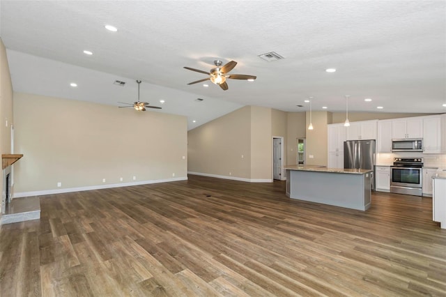 unfurnished living room with vaulted ceiling, hardwood / wood-style flooring, ceiling fan, and a textured ceiling