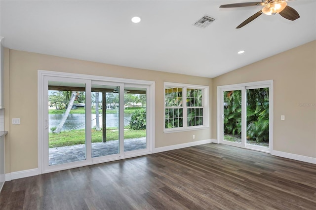 interior space featuring dark wood-type flooring, ceiling fan, vaulted ceiling, and a healthy amount of sunlight