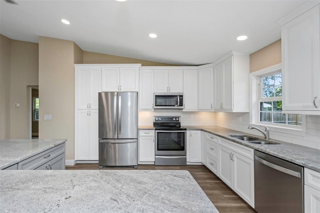 kitchen with white cabinets, lofted ceiling, and appliances with stainless steel finishes